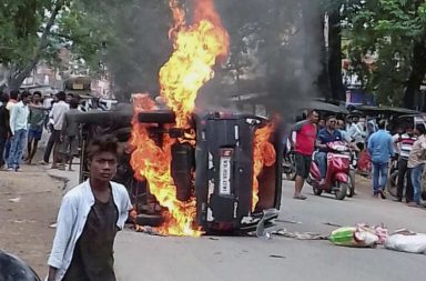 Members of a community torch a vehicle during a protest against lynching of a man in Ramgarh in Jharkhand